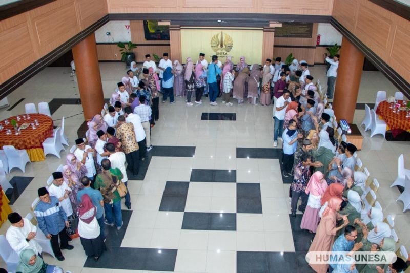 Jajaran pimpinan Universitas Negeri Surabaya bersama seluruh jajaran pejabat rektorat, fakultas, koorprodi, dosen dan mahasiswa bersalam-salaman dalam halalbihalal di lobi rektorat.