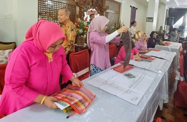 Peserta pelatihan praktek menyesuaikan pola busana yang dibuat pada bahan atau kain yang kemudian dijadikan produk busana ramah lingkungan