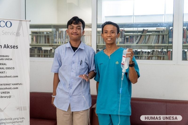 SEMANGAT: Didampingi perawat, Muhammad Aimanur Razzaq, peserta tes UTBK UNESA asal Gresik hadir dengan infus terpasang di tangannya.