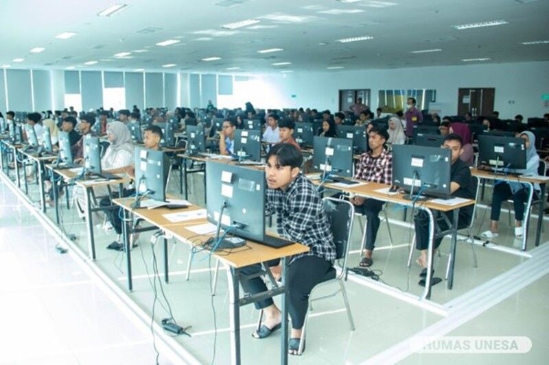 Semua peserta tes UTBK tampak mengenakan sandal yang disiapkan Unesa.
