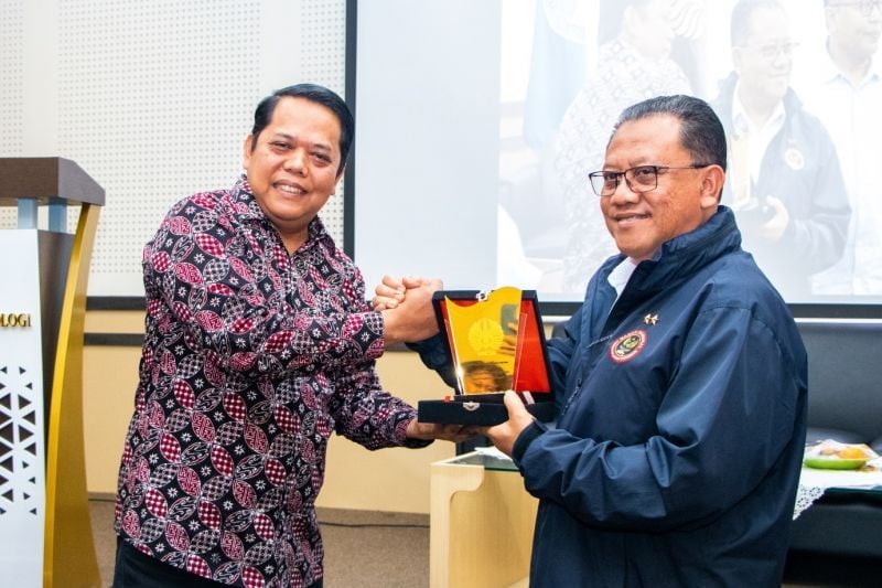 Wakil Rektor III UNESA menyerahkan cinderamata kepada narasumber.