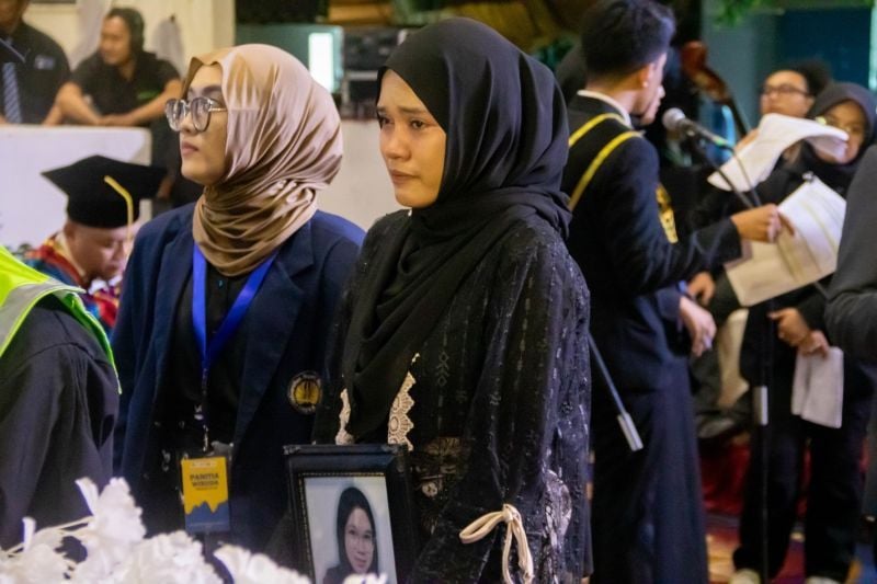 Jauh-jauh dari Pulau Kangean, Nur Malinda tampak haru dan tegar menghadiri momen wisuda kakanya, Nur Ifiana yang kini dalam kenangan keluarga besar UNESA.